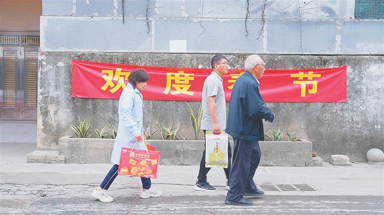 1月28日，程相文（右）带着年货去拜年。《守穗》拍摄团队供图